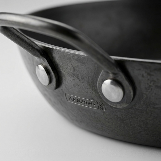 Tramontina 15-Inch Carbon Steel Paella Pan handle rivet and texture close-up