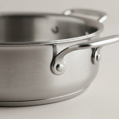 Close-up of the Tramontina Signature 3 Qt Braiser riveted handle and brushed stainless steel finish.
