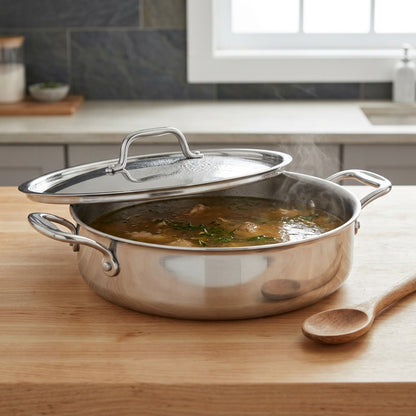 Tramontina Signature 6 Qt Tri-Ply Clad Covered Braiser on a wooden countertop lifestyle shot.
