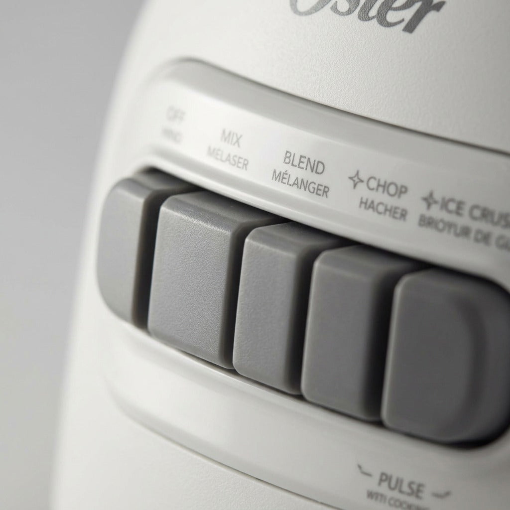 Macro close-up of gray control buttons on the white Oster 2169693 blender base.