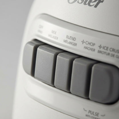 Macro close-up of gray control buttons on the white Oster 2169693 blender base.