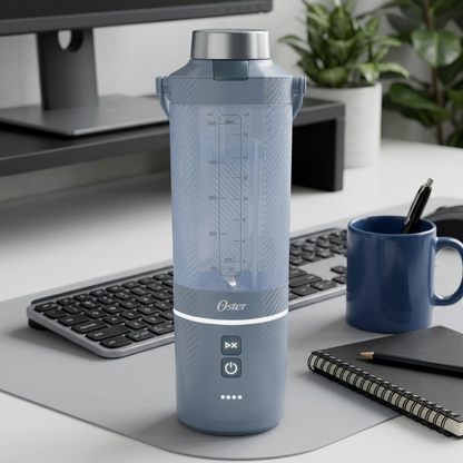 Oster Oster 2219802 GoMAX blender on a desk beside a coffee mug, notebook, and standard keyboard.