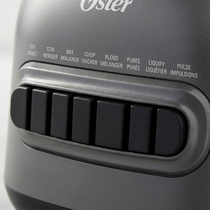 Macro detail of the Oster 8-Speed Blender control panel featuring black push buttons and bilingual labels.
