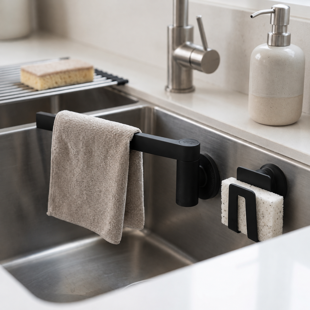 Porte-éponge et porte-linge magnétique Happy Sinks noirs fixés sur un évier en acier inoxydable