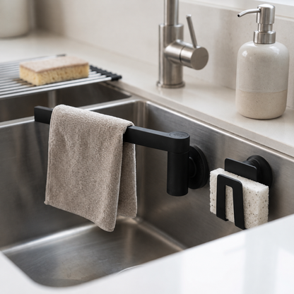 Porte-éponge et porte-linge magnétique Happy Sinks noirs fixés sur un évier en acier inoxydable