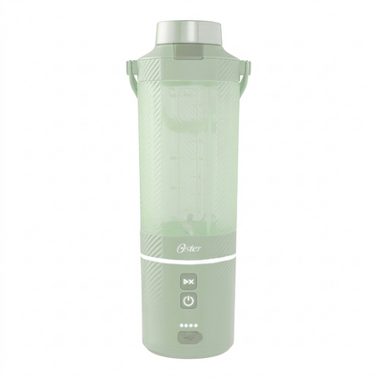 A hand sits beside the Matcha Green Oster GoMAX Portable Blender on a desk for scale reference.